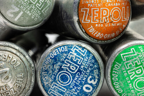 Tight view of a collection of Zeroll brand antique ice cream scoops with patent markings.